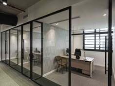 an office with glass walls and desks