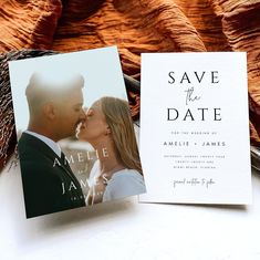 save the date cards with an image of a man and woman kissing in front of them