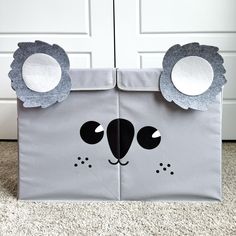 an animal themed storage bin with ears and eyes on the front, in front of a door