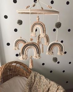 a crocheted mobile hanging from the ceiling in a child's room with polka dot wallpaper