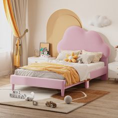 a bedroom with a pink bed and white dressers in it, along with other furniture