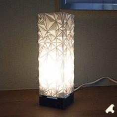 a white lamp sitting on top of a wooden table