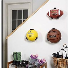 sports themed items are displayed on the wall in this entryway area, including basketballs and boots