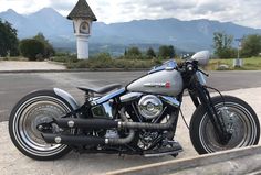 a motorcycle parked on the side of a road near a clock tower in the background