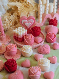 there are many pink and white hearts on the table with other small items in front of them