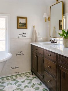 a bathroom with two sinks and a bathtub next to a large mirror on the wall