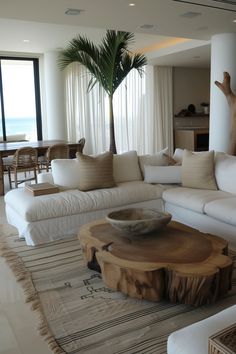 a living room filled with furniture and a palm tree in the middle of the room