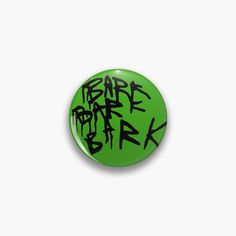 a green button with black graffiti on it