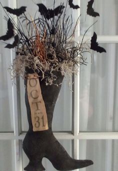 a black boot with bats on the window sill and a sign that says coco