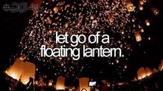 the words let go of a floating lantern are lit up in the dark night sky