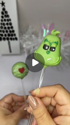 someone is holding a green cake topper in their hand and it looks like they are angry