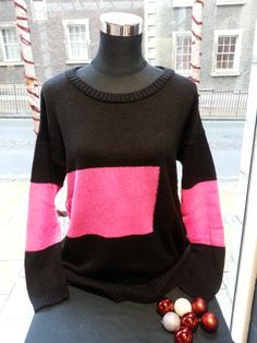 a black and pink sweater sitting on top of a mannequin's head