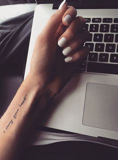 a woman's hand with a small tattoo on her left wrist and the words your heart, tatoologist