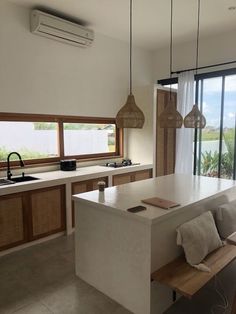 a kitchen with an island, sink and window overlooking the ocean is shown in this image