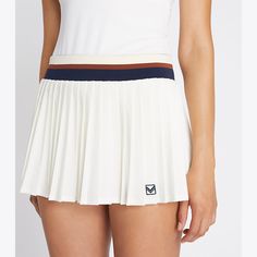 Our best-selling Pleated Tennis Skirt is updated with a mini silhouette. Lightweight and breathable, the classic design is also moisture wicking with great stretch and recovery. A striped elastic waistband and built-in boy short ensure comfort and ease of movement. White Pleated Sports Bottoms, Classic Stretch Tennis Skirt For Summer, Classic Stretch Skort For Summer, Sporty White Mini Skirt With Elastic Waistband, White Pleated Sporty Shorts, Sporty Pleated Shorts, Classic White Stretch Skort, Sporty White Pleated Shorts, Striped Fitted Short Length Skort