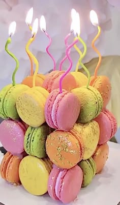 a cake made out of macaroons with lit candles