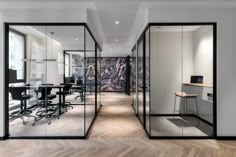 an office with glass walls and wooden floors