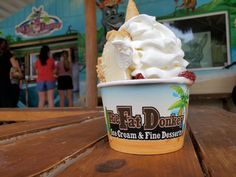 an ice cream sundae sits on a picnic table