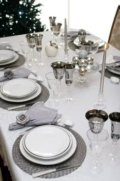 the table is set with silver and white dishes