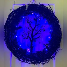 a blue lighted wreath with a tree on it