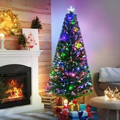 a brightly lit christmas tree sitting in front of a fireplace