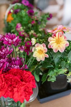 colorful flowers are arranged in glass vases on a table