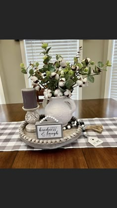 a white vase filled with flowers on top of a table