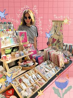 a woman standing in front of a table with many items on it, including cards