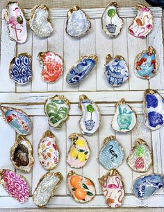 an assortment of colorful ceramic ornaments on display in a white tray with gold trimmings