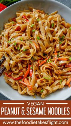 vegan peanut and sesame noodles in a white bowl with chopsticks on the side