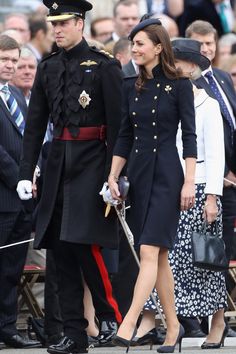 the royal couple are walking down the street