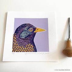 a painting of a bird on a purple background next to a paintbrush and small piece of paper