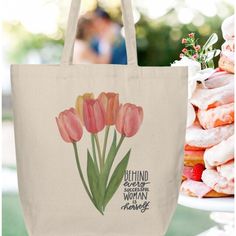 a tote bag with pink flowers on it next to donuts