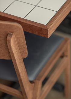 a close up of a wooden chair with tile on the back and seat padding