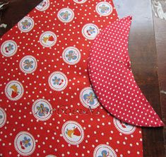 two pieces of red and white polka dot fabric sitting on top of a wooden table