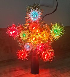 a vase filled with colorful lights on top of a wooden table