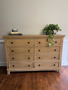 a wooden dresser with a potted plant sitting on it's top and bottom