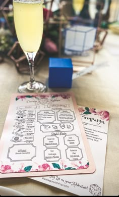 a glass of wine sitting on top of a table next to a menu and blue cubes