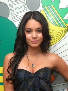 a young woman standing in front of a colorful wall