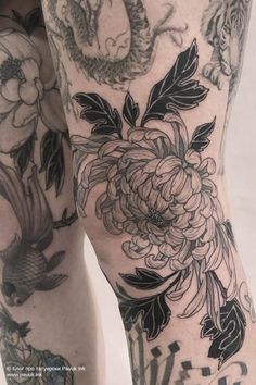 a woman's legs with tattoos and flowers on them