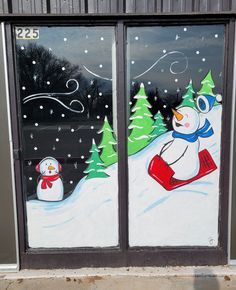 two frosted glass windows with snowmen and trees painted on them