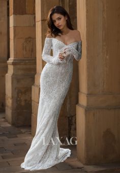 a woman in a wedding dress leaning against a pillar