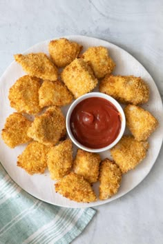 some fried food on a plate with ketchup and dipping sauce in the middle