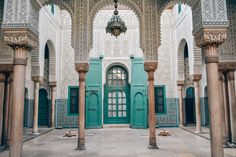 an ornate building with green doors and pillars