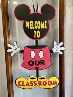 a mickey mouse welcome sign is displayed in front of a glass case that says, welcome to our class room