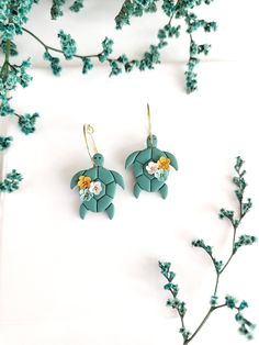 the sea turtle earrings are green and have flowers on them