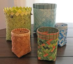 four different colored baskets sitting on top of a wooden table next to each other,