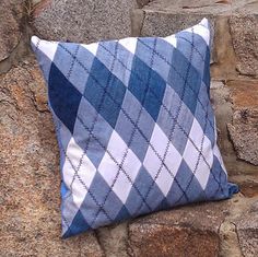 a blue and white pillow sitting on top of a stone wall