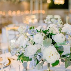 a vase filled with white and blue flowers on top of a table