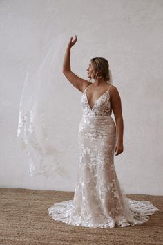 a woman in a wedding dress holding her veil